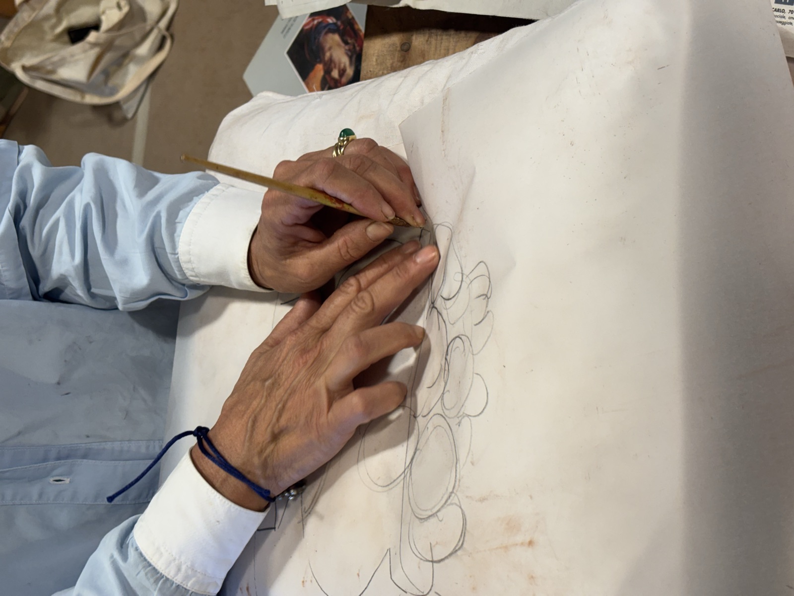 Mani di una persona del corso che disegna sul cartone dell'affresco