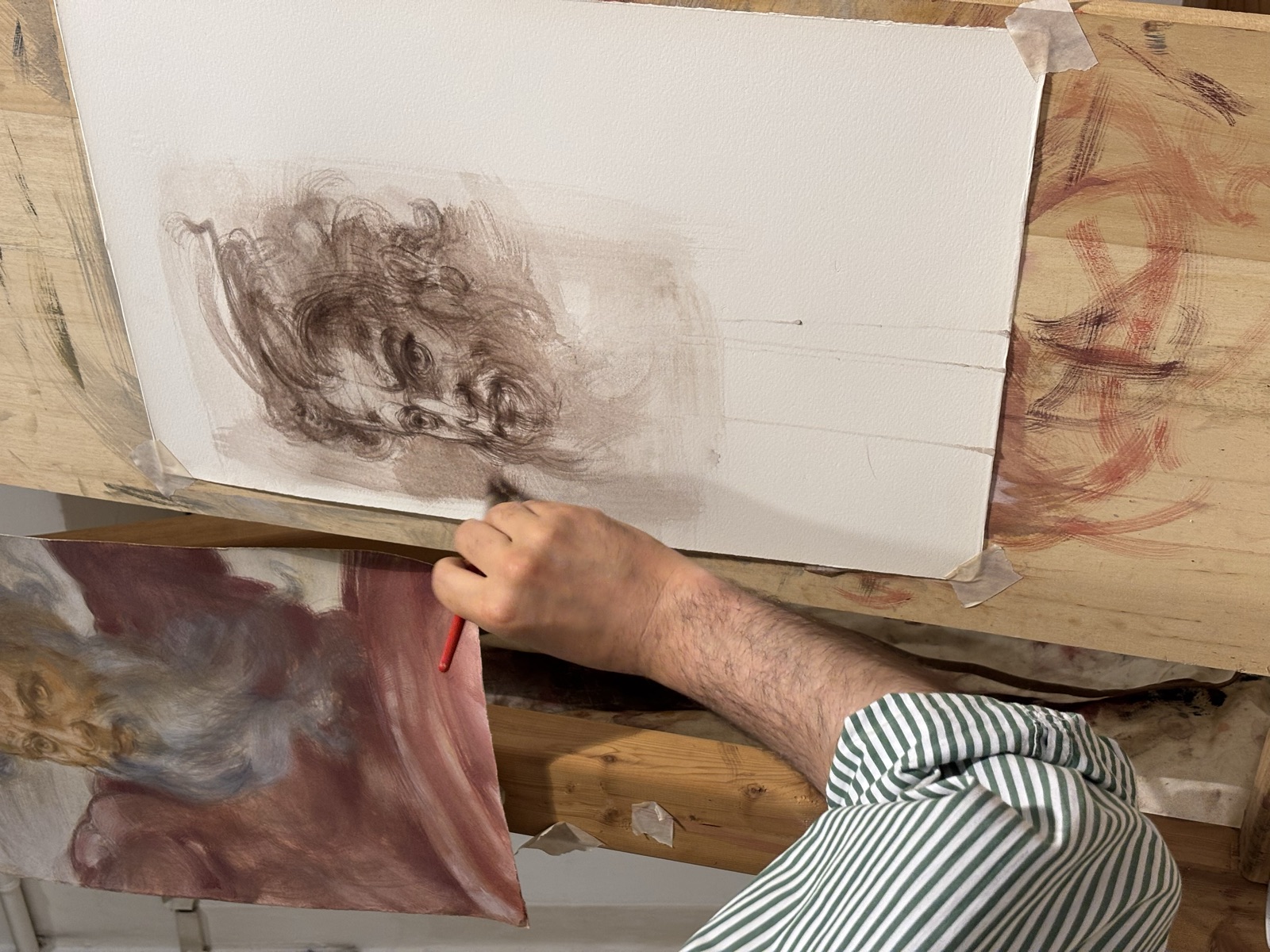 Una mano disegna uno studio di testa in sanguigna