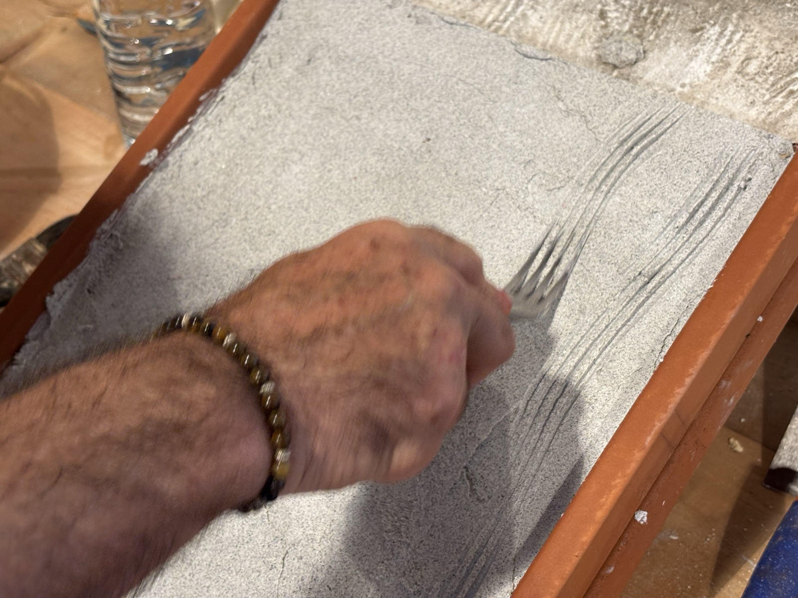 Una mano liscia l'intonaco fresco di calce