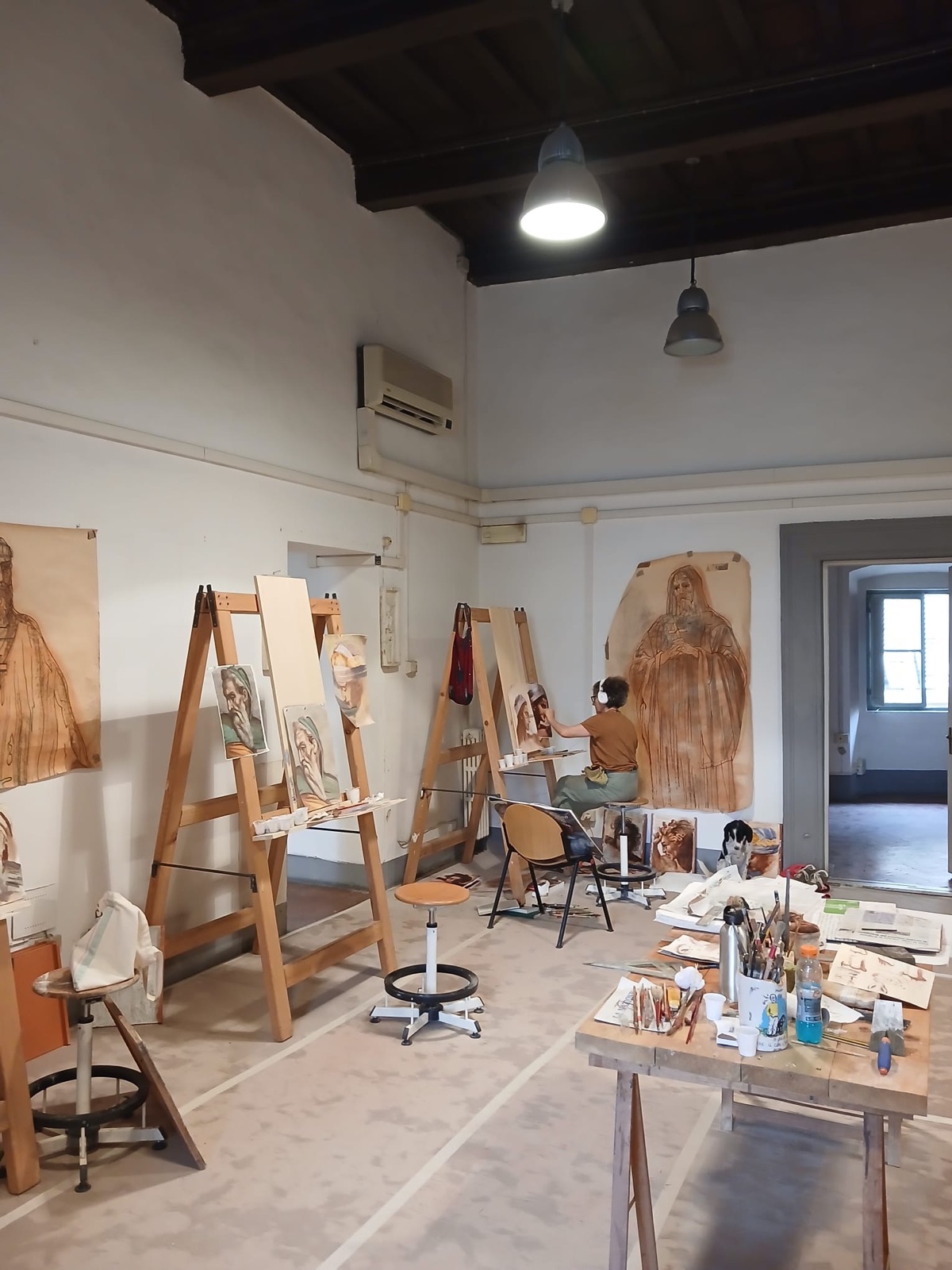 Aula piena di cavalletti e di studi degli allievi